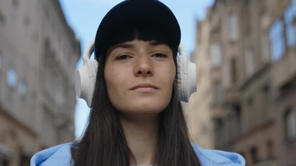 Piękna Dziewczyna Słuchawkach Stojących Patrząc Aparat Pokojowa Pani Słuchawkach Bezprzewodowych — Wideo stockowe