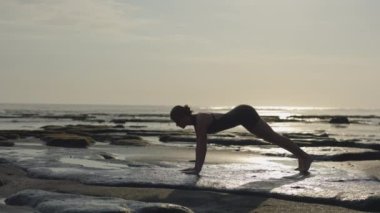 Sportif Genç Kadın Yukarı Doğru Köpek Yogası Konumunda Sahne Okyanusu Kıyısında, Açık Hava Uzatma Egzersizleriyle Vücudunu Eğitiyor. Fitness Bayan Eğitimi Dışarıda
