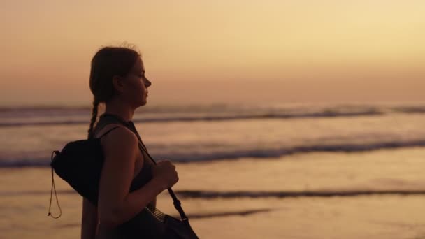 瘦身的女运动员经过严格的训练后 在海滩上悠闲自在地漫步 训练者瑜伽课开始前在海滨进行 体育与人的概念 — 图库视频影像