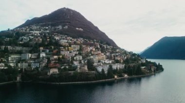 Dağların ve Lugano Gölü 'nün göz kamaştırıcı manzarasının hava görüntüsü. Lugano, İsviçre 'de çekilmiş. Güzel Doğa. Şehrin İHA 'sı gölün yakınındaki Alps Tepesi' nde. Seyahat ve Turizm Konsepti