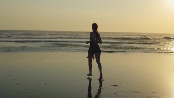 日落时分 年轻的白种人女孩在海滩上奔跑 斯利姆 布朗德女士跑步训练 慢跑者 体育与人的概念 — 图库视频影像