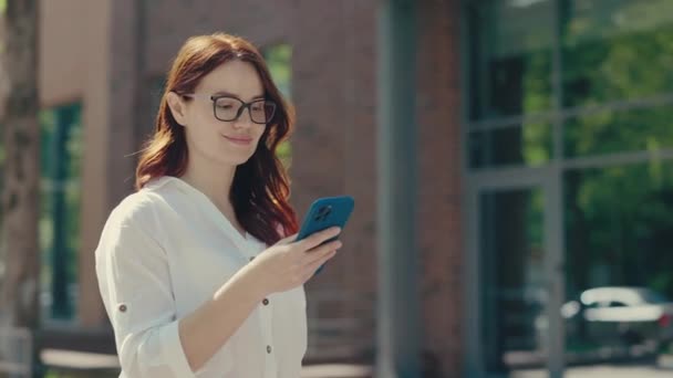 Ginger Üzletasszony Szemüvegben Hivatalos Öltönyben Bemegy Üzleti Központba Mobilon Sms — Stock videók