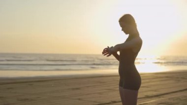 Spor Giyim 'de Sportif Sarışın Kadın Sahilde Duruyor ve Akıllı Saat Kullanıyor. Atletik Kız Dijital Saat 'te Nabzı Kontrol Ediyor. Halk, Spor ve Teknoloji Konsepti