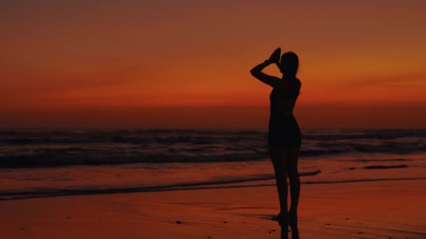 身材苗条的女人站在外面的夕阳西下手在纳马斯特 苗条的女孩站在海滩上 夫人默默室外 瑜伽与人的概念 — 图库视频影像