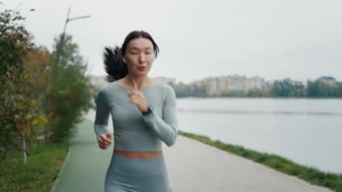 Genç atlet Asyalı kız kalorileri hesaplamak için koşuyor ve dışarıya bakıyor. Fitness Egzersiz Ekipmanı Uygulama Teknolojisi Etkin Aygıtı