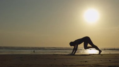 Beyaz kız kendini Yoga Sanatı 'na adadı. Spor koçu zarifçe Sun Kissed Sahili 'nde egzersiz yapıyor. Spor ve İnsanlar Konsepti