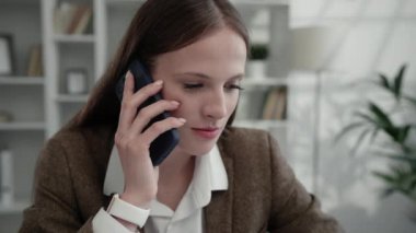 Ciddi Patroniçe Evden Uzaktan Çalışırken Sorulara Telefonla Cevap Veriyor. Evde otururken telefonda konuşan genç kız. İş kadını ve Teknoloji Konsepti