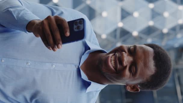 垂直录像 用智能手机微笑站在街上的非裔美国人 快乐商人户外运动社交媒体在移动 人与技术概念 — 图库视频影像