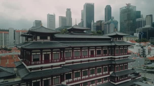 壮大な仏陀の歯の遺跡は 曇りの日に現代のシンガポールのスカイラインの前に顕著に立っています アリアルビュー ドローンショット — ストック動画