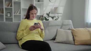 Gülümseyen Cazibeli Bayan İnternet Tarayıcı Daire 'de otururken Cep telefonunu kullanıyor. Kafkas Kadın Gözlükleri Akıllı Telefon 'da. Halk ve Teknoloji Konsepti