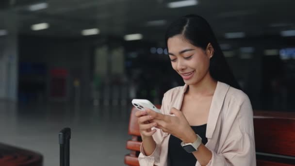 Young Traveler Woman Relaxing Airport Lobby Using Smartphone Texting Friends — Stock Video