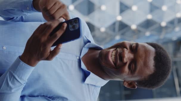 Vídeo Vertical Sonriente Hombre Negocios Afroamericano Parado Afuera Usando Smartphone — Vídeo de stock