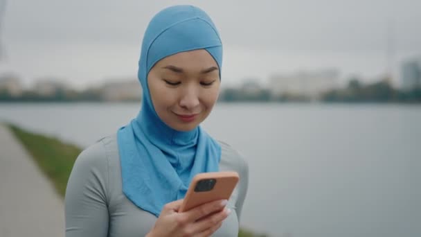 Eğitimden Sonra Gölde Yürürken Akıllı Telefon Kullanan Güzel Müslüman Bir — Stok video
