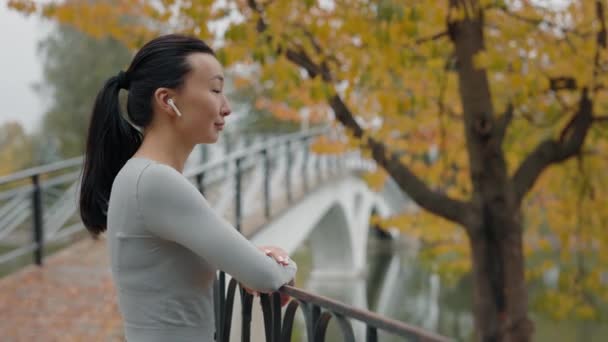 Vista Lateral Corredora Asiática Disfrutando Afuera Escuchando Música Jogger Woman — Vídeo de stock