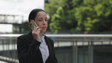 Ofis personeliyle telefonda konuşan Etnik İş Kızı. Ciddi Patroniçe dışarıda Smartphone 'la ilgili konularda karar veriyor. Halk ve Teknoloji Konsepti