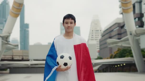 站在法国国旗和手握球的多种族年轻人的画像 亚洲球迷穿着法国国旗和足球球站在镜头前 足球与人的概念 — 图库视频影像