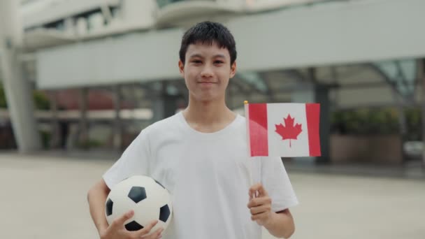 Retrato Menino Asiático Sorridente Com Bola Futebol Segurando Bandeira Canadense — Vídeo de Stock