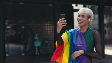 Gökkuşağı Bayrağı Giyen Yakışıklı Genç Adam Görüntü Arıyor, Ekrana El sallıyor. İnternetteki Transseksüel Konferansı LGBT topluluğundan insanlarla konuşuyor. LGBT ve Teknoloji Konsepti