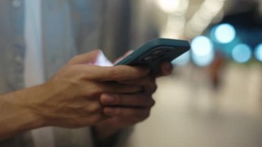 Erkek Elleri Akıllı Telefonu Tutuyor ve Gece Şehrinde Mesaj Duruyor. Meşgul Adam cep telefonunu iş için kullanıyor. Görüntüyü Kapat. Teknoloji ve İnsanlar Konsepti