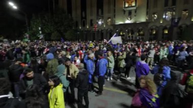 Tiflis, Gürcistan - 12 Mayıs 2024: Gürcistan Parlamentosu önünde Şehir Işıkları Arkaplanı Arkasında Yabancı Ajanlar Yasasını protesto eden enerjik bir kalabalık toplandı