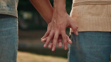 Genç adam, Summer City caddesindeki yakın çekimde erkek arkadaşının elini yürütür. Romantik bir randevuda eşcinsel çift. Gurur ayında LGBT toplumunu destekle