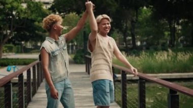 Gülümseyen sarışın adam, Spring Park 'ta eşcinsel partneriyle dans ediyor. Mutlu genç homoseksüel çift romantik bir randevuyu bahçede geçirir. LGBT Topluluğu Sevgi ve Özgürlük Gurur Ayı