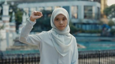 Genç Müslüman Kız elini kaldırıyor ve kameraya bir destek işareti gösteriyor. 