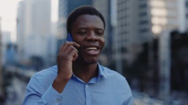 Genç Pozitif Lider sokakta yürüyor ve telefondaki eşyalarıyla konuşuyor. Kendine güvenen Afrikalı Amerikalı Ofis Adamı Çalışma Yeri 'ne gidiyor ve cep telefonuyla konuşuyor. Halk ve Teknoloji