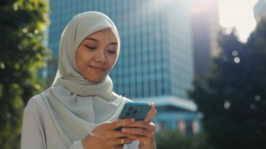 Müslüman Kadın Kocasıyla Mesajlaşıyor ve Telefonundan Hoş Mesajlar Alıyor. Güzel, İslami Kız Arkadaşlarıyla Canlı Sohbetler ve Telefonuna Gülümseme. Halk ve Teknoloji