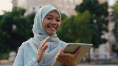 Başörtüsü Giyen, Tablet Giyen, Uzaktan Çalışan ya da Grubu Selamlayan Genç Kadın. Disaridaki Video Konferansinda Dijital Cihazli İslami İş Kadini. Halk ve Teknoloji Konsepti