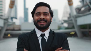 Beyaz gömleğin üzerine siyah kravat takan esmer Hintli erkek portresi ve gülümseyerek kameraya bakıyor. Orta yaşlı işadamı kariyerindeki hedeflere ulaşılmasından dolayı geleceğinden emin..