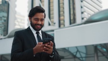 Şok olmuş klas kıyafetli işadamı finans bölgesinde akıllı telefon kullanarak zafer hamlesi yapıyor. Memnun komisyoncu e-postayı kontrol ediyor ve kârlı yatırım hakkında mesaj alıyor.
