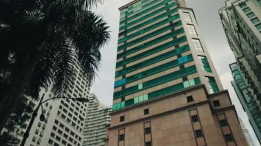 Şehrin merkezindeki modern bina diğer Gray High-Rise binaları arasında. Mavi Panoramik Pencereli Ofis Binası. İş ve Binalar Kavramı