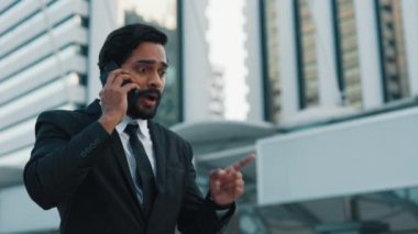 Şirketin stresli patronu cep telefonuyla konuşuyor ve gökdelenlerin yanında dururken işaret parmağıyla el sallıyor. İşçilere talimat veren ve teslim tarihlerini belirleyen ciddi bir adam..