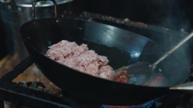 Kırmızı biberleri yağda kızartıp domuz eti suyu içerken derin demir tavayı açıda tutan tanınmaz bir mutfakçı. Parlak tat ve aromalı ana et yemeği için orijinal tarif.
