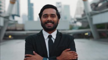 Kendine güveni tam bir şirket lideri, elleri belinde tutarken kameraya mutlu bir ifadeyle gülümsüyor. İş elbisesi giymiş olgun bir insan kariyer geliştiriyor ve girişimcilikte yol gösteriyor..