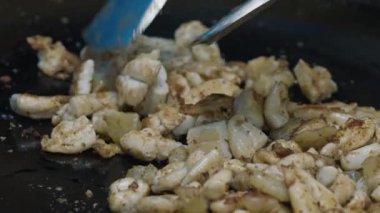 Sokak yemekhanesinde çırpılmış kalamar yumurtası kesiliyor ve birkaç spatulası olan görünmez şef tarafından döndürülüyor. Tayland 'daki gece pazarında satılık yağlı büyük tavada yerel deniz ürünleri..
