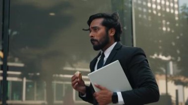 Yakışıklı Hintli işadamı elinde modern bir aletle hızla ofis binasının önünden geçiyor. Aceleyle yemek yiyen genç bir erkek vardiyayı kontrol ediyor ve işe geç kalıyor..