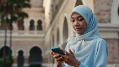 Tesettürlü Genç Kadın Telefonundan İyi Haber Aldı. Şok Olan Güzel Olumlu Müslüman Kız Sokakta Duruyor ve Telefonda Bir Anlaşmayı Kapatıyor. P4eople ve Teknoloji Konsepti