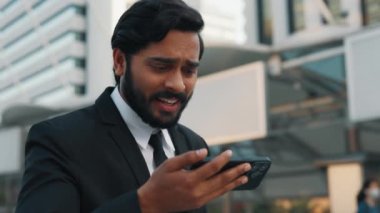 Açık havada dururken cep telefonuyla spor şampiyonasını izleyen, forma giymiş hevesli bir adam. Şanslı çalışan işe giderken ve para ödülünü kazanırken başarılı bir bahis yapıyor..