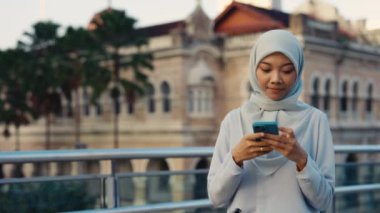 Geleneksel Giysiler İçinde Çekici Pozitif Kadın Dışarıda Arkadaşlarıyla Cep Telefonunda Mesajlaşıyor. Caddedeki Hijab 'da Büyüleyici Kız Ailenle Sohbet et, Akıllı Telefon Kullan.