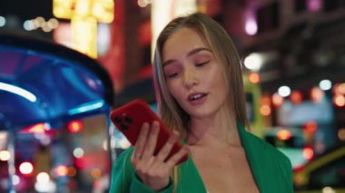 Beyaz saçlı, güzel bir kadının portresi. Akıllı telefonuyla konuşuyor. Gece şehrinde eller serbest. Yeşil ceketli kadın alışveriş merkezinde telefonla iletişim kuruyor. Ses tanıma