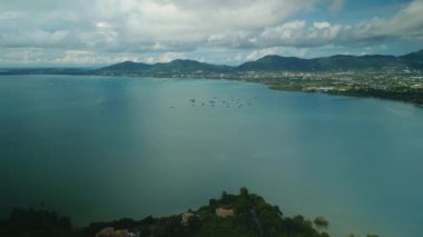 Deniz, kıyı ve uzak dağlar arasında deniz manzaralı adalar grubu. Kabarık bulutlar altında Asya tatil köyünün pitoresk tropikal manzarası. Tatilde Tayland 'a gidiyorum.