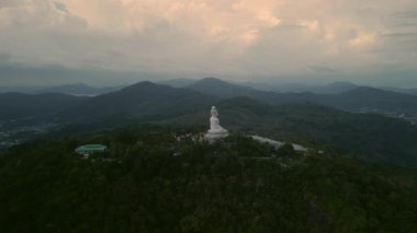 Phuket Büyük Buda heykeli tepede nilüfer pozisyonunda eski dağların hava manzarasına karşı. Budizm 'le ilgilenen turistleri çeken dini anıt. Gün doğumunda Asya 'nın simgesi