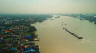 Kasvetli bir günde Bangkok 'ta, kıyı boyunca uzanan Chao Phraya Nehri Kargo Tekneleri ve Renkli Evlerin Havadan Görünüşü