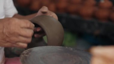 Polimer kilin yarısı küçük el sanatları atölyesinde hizalama dokusu için elle cilalanır. Üretken bir günde yüksek kalitede tasarımcı ürünü üzerinde çalışan seramik ustası.