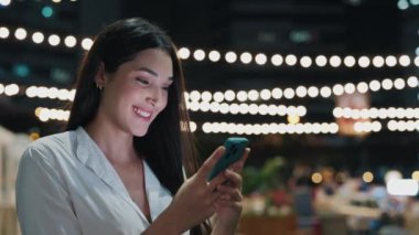 Mutlu Kadın Kafe Sahibi, dışarıda dikilirken akıllı telefonunu kullanarak iş yerinde sohbet ediyor. Güzel, pozitif kız telefonuyla mesaj atıyor ve SMS 'e gülümsüyor. Halk ve Teknoloji
