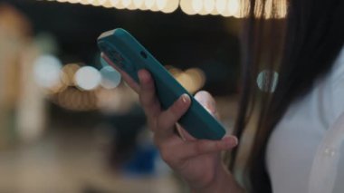 İnternetteki Kadın Akıllı Telefon ve Kaydırma 'nın Yakın Görüntüsü. Uzun saçlı kız dışarıda duruyor, haberleri okuyor, internette geziniyor. Halk ve Teknoloji Konsepti