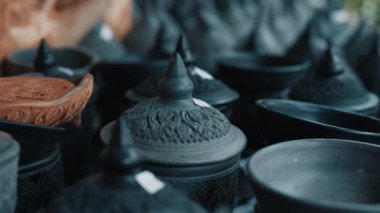 Üzerinde fiyat etiketleri olan kapaklı Tayland kil çömleklerine odaklan. Geleneksel Asya el sanatları, halk sanatı ve kültürünü temsil eden siyah renklerle boyanmış..