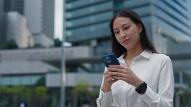 Şirin Asyalı İş Kadını Müşterilerle İş Binası 'nın önünde mesajlaşıyor. Güzel Öğretmen Bayan Açık havada Öğrencilerle Akıllı Telefon Kullanarak Sohbet Ediyor. Halk ve Teknoloji Konsepti